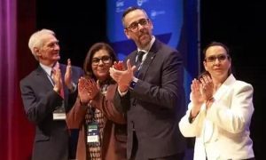 Profissionais do Direito em celebração ao evento jurídico, demonstrando reconhecimento e entusiasmo em ambiente formal de conferência ou seminário.