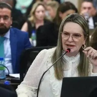 Advogada participando de audiência no tribunal, apresentando argumentos jurídicos durante sessão de direito.