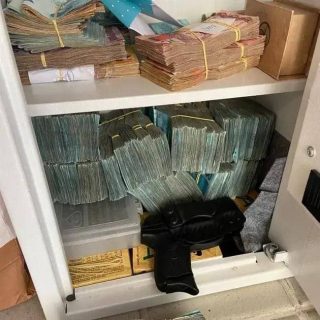 Pilhas de dinheiro guardadas em cofre, destacando segurança financeira, dinheiro em espécie, economia, e proteção de recursos.
