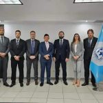 Brasileiros e representantes internacionais em evento jurídico, com bandeiras do Brasil, Panamá, Guatemala e ONU, promovendo cooperação e diálogo na área de direito e justiça.