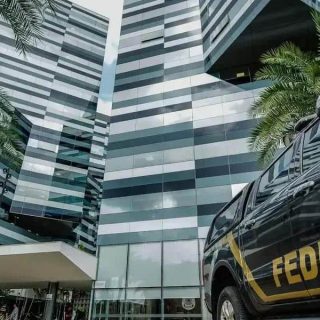 Polícia Federal realizando diligências em prédio corporativo moderno, ressaltando operações de combate ao crime no Brasil.
