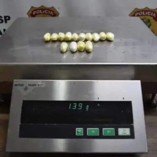 Moradores sendo flagrados com drogas apreendidas pela polícia em operação. A balança digital mostra o peso de 139g, indicando possível tráfico de drogas na região.