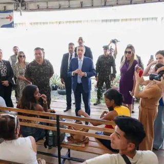 Ministro da Justiça conversa com visitantes em evento de direitos humanos, destacando políticas públicas e justiça social no Brasil.
