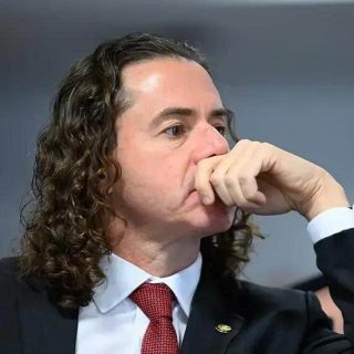 Inspetor de justiça pensativo durante sessão no tribunal, usando terno, demonstrando reflexão sobre questões jurídicas e de direito na sala de audiência.