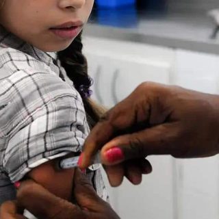 Vacina infantil sendo aplicada por profissional de saúde com foco em imunização e direitos das crianças na área de saúde.