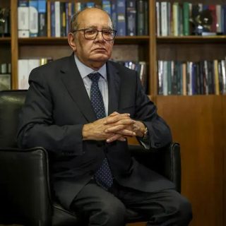 Advogado idoso em escritório com livros de direito ao fundo, representando notícias de direito e atuação jurídica.