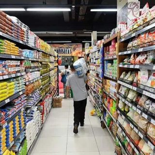 Pacientes com máscara de gás caminhando por corredor de supermercado com prateleiras repletas de alimentos e produtos embalados, no contexto de notícias de direito e saúde.