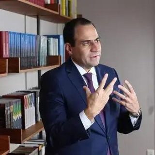 Professor em entrevista na biblioteca, discutindo temas de direito e legislação.