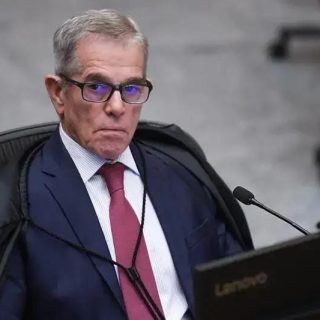 Associação de profissionais do direito em uma audiência judicial com juiz sentado, expressão séria, ambiente de tribunal formal, evidenciando temas de direito, justiça e legislação.