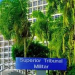 Superior Tribunal Militar, edifício com palmeiras na frente, clima ensolarado, foco nas questões jurídicas militares e notícias do direito militar.