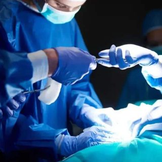 Cirurgiões realizando procedimento cirúrgico em sala de operação com equipe médica, foco na importância do direito à saúde e avanços na medicina.