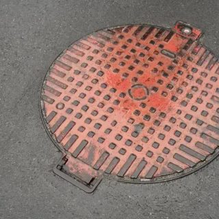 Duto de saneamento aberto na rua, manhole cover, manutenção urbana, infraestrutura de cidades, projetos de saneamento básico.