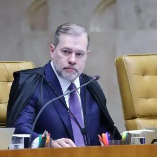 Juiz de tribunal federal em sessão de julgamento, sentado em cadeiras de tribunal, representando o direito e a justiça, com expressão séria e profissional, com cadeira destaque e documentos ao seu redor.