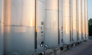 Tanques de armazenamento de líquidos metálicos em instalações industriais, representando segurança e regulamentação ambiental.
