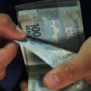Dinheiro em cédulas de 100 reais sendo contado, foco em economia e finanças, destaque para legislação e notícias de direito hoje.