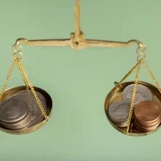 Balança de moedas representando questões financeiras e jurídicas, simbolizando o equilíbrio e a justiça nas decisões legais relacionadas a direito e economia.